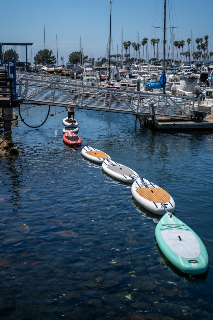 a-group-of-paddle-boats-floating-on-top-of-a-body-of-water-k4i5cdbhqw