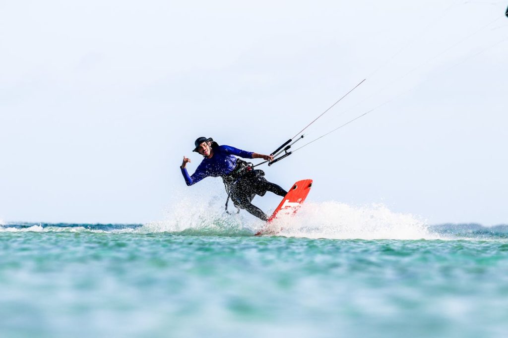 A thrill-seeker kitesurfing on the open ocean, showcasing skills and joy.