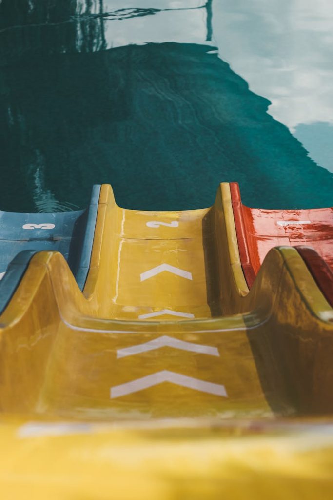 Close-up view of a vibrant water slide leading into a swimming pool.